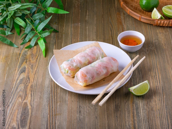 Fototapeta Summer rolls with fresh vegetables and shrimps and peanut sauce. Vietnamese appetizer. Salad spring rolls with prawns. Healthy food concept