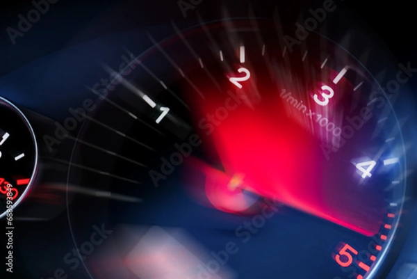 Fototapeta Motion blur of a car instrument panel dashboard odometer with red illuminated display.Car speedometer. High speed car speedometer and motion blur at night.