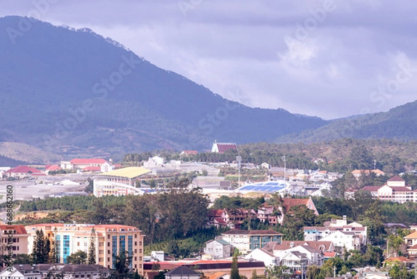 Fototapeta View on roofs in the city of Dalat. Da Lat and the surrounding area is a popular tourist destination of Asia. City with fogs and mountains