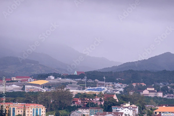 Fototapeta View on roofs in the city of Dalat. Da Lat and the surrounding area is a popular tourist destination of Asia. City with fogs and mountains