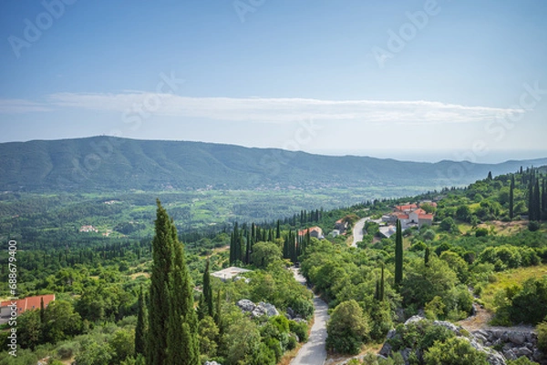 Obraz View from Sokol fortress, Croatia, to cliffs grown with green cypresses and road through the valley