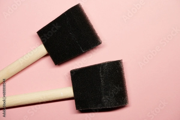 Obraz Two black foam paintbrushes on pink surface