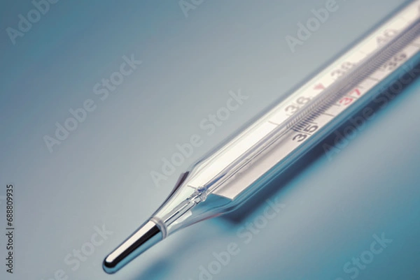 Fototapeta mercury thermometer close-up on a blue background