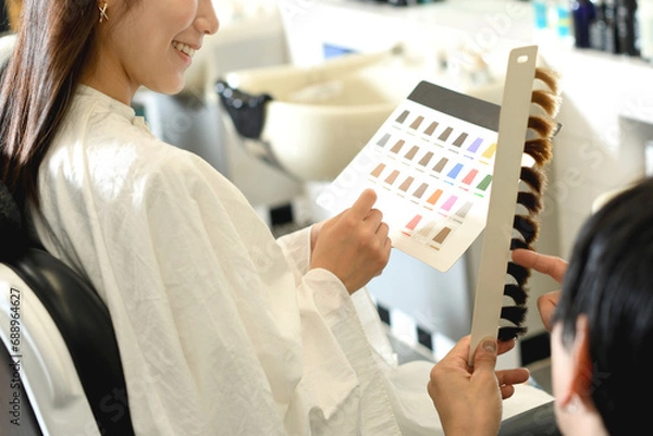 Obraz 美容室でヘアカラーを選ぶアジア人の女性客