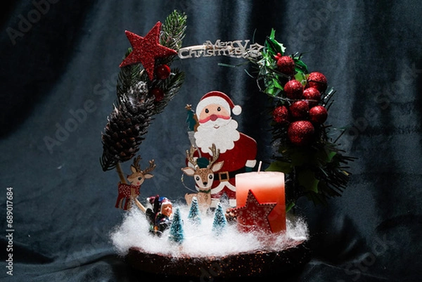 Fototapeta Christmas wreath in the form of a star Blue lights. Symbolic Christmas balls and ornaments. Green, white. On a black background
