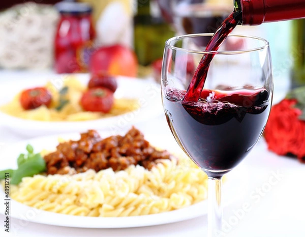 Obraz Pouring red wine and food background
