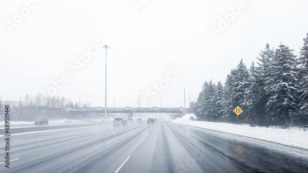 Obraz Driving down the highway during a winters storm in Ottawa, Ontario. Road is covered by snow, cars, passing by, fog