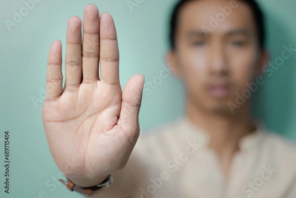 Fototapeta Man shows hand to stop or prohibit With a calm expression, the Asian man made a gesture,