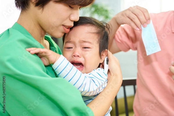 Obraz 泣いている幼児をあやす両親