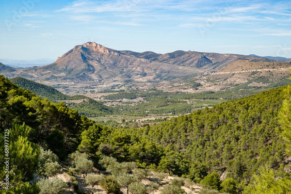Fototapeta Panoramic view of the Peña de Jijona, traditionally known as the Peña Roja, at the foot of which is the municipality of Jijona, famous for the production of nougat.
