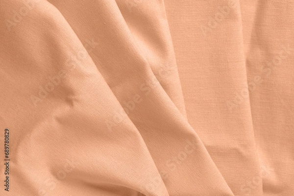 Fototapeta Textured folds of fabric in peach color