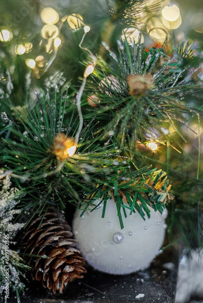 Fototapeta Christmas white ball on a festive tree. Bokeh and blurred background. Shallow depth of field.