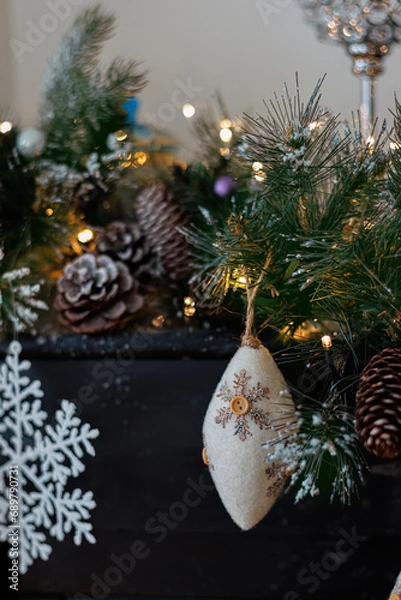 Fototapeta Christmas background with pine branch and beautiful yellow shiny bokeh. Wool pine cone. White snowflake. Shallow depth of field