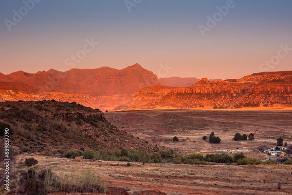 Fototapeta A few scattered huts and buildings against the backdrop of mountains in Lesotho, Africa