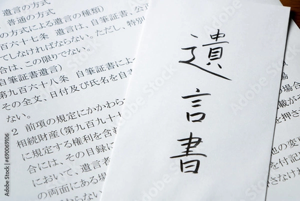 Obraz 遺言書と書かれた封筒と、民法の条文の書かれた紙。