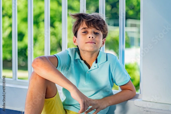 Fototapeta Handsome smiling teenager's portrait on green garden background