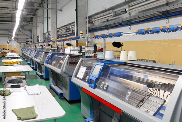 Obraz A row of industrial textil flat knitting machines in a knitwear factory.