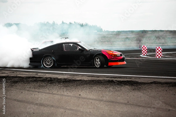 Fototapeta Adrenaline sport scene car drifting in carpark with lot of smoke from burning tire