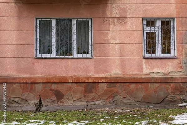 Fototapeta Two white window with bars in a wall covered with plaster