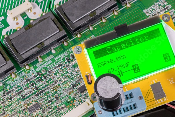 Fototapeta Measuring the capacitance of an electrolytic capacitor. Microcircuit on a black background. Electronic components. Microfarats.