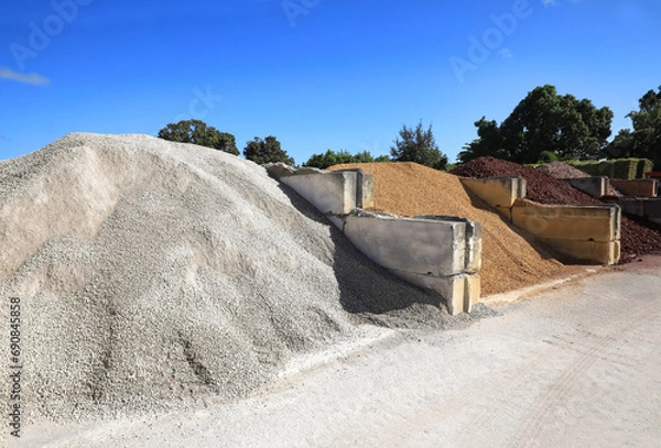 Fototapeta Large quantities of different landscaping rocks, recycled concrete, stones, sand and fill for sale at a local supply shop.