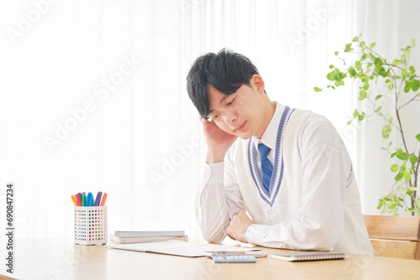 Fototapeta 自宅で勉強中に考える男子高校生