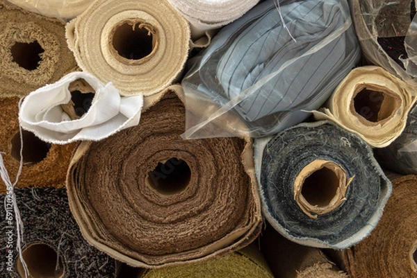 Fototapeta Close-up of stacked rolls of fabric of different materials