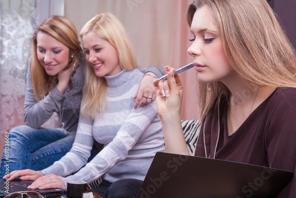 Obraz Lifestyle Concept. Three Winsome Happy Laughing Caucasian Girlfriends Working With Laptop Together Indoors.
