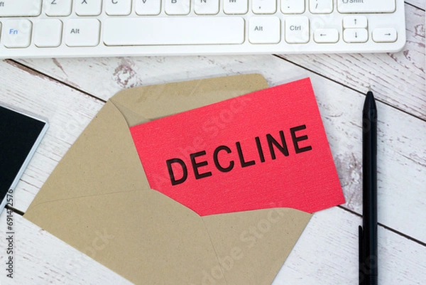 Fototapeta Decline text on red card with envelope, white keyboard and pen on wooden table.