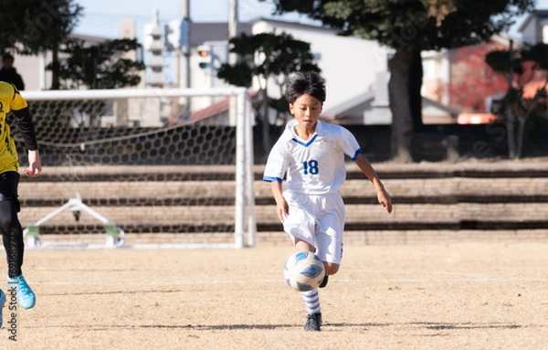 Fototapeta サッカーの試合をする小学生の男の子