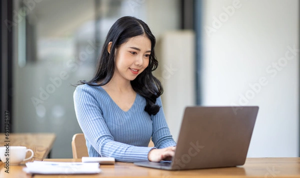 Fototapeta Asian Business woman using calculator and laptop for doing math finance on an office desk, tax, report, accounting, statistics, and analytical research concept
