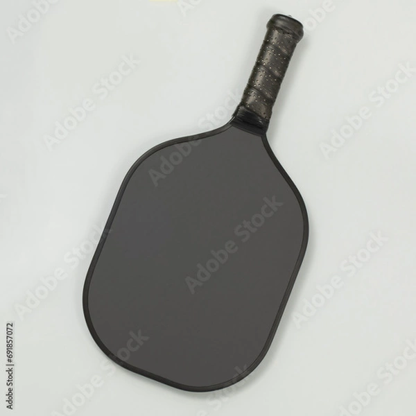 Obraz Top view of a black blank pickleball paddle on light gray background with copy space. Square composition