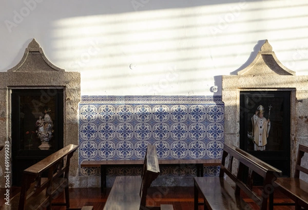 Obraz Church interior with portuguese handmade tiles and religious small statues. Azulejos portugueses