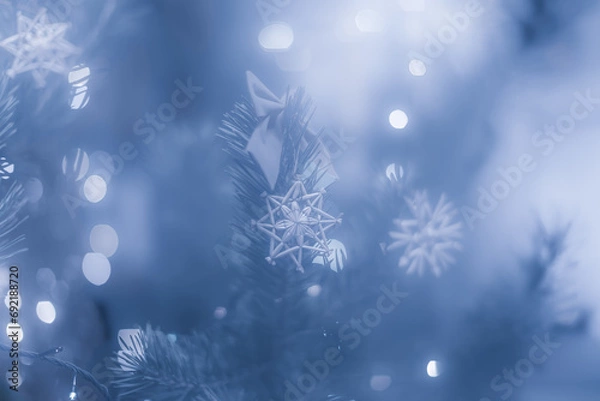 Fototapeta Straw snowflakes on christmas tree branch and bows in blurred background.