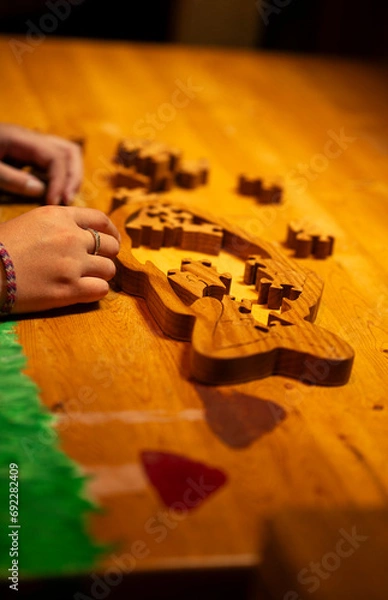 Fototapeta a kid playing with a wooden puzzle