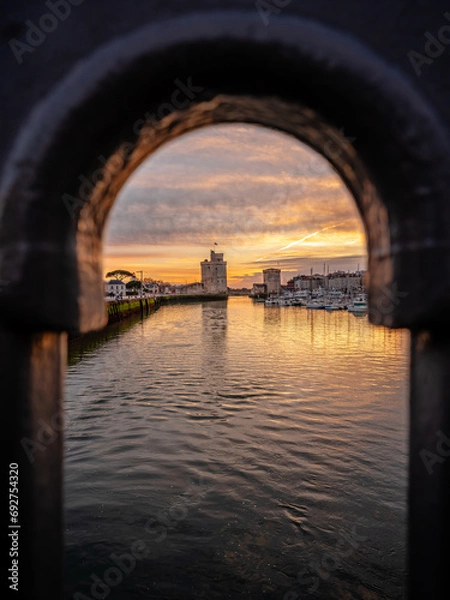Obraz view through balustrade of the old harbor of La Rochelle at blue hour with its famous old towers.
