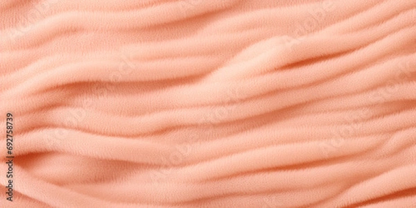 Fototapeta A close up view of a pink blanket. Monochrome peach fuzz background.