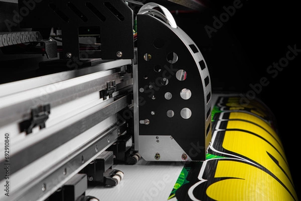 Fototapeta view of Closeup of Large Inkjet printer in working with multi color cmyk colors in containers on vinyl banner