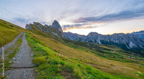 Obraz Dolomites' Seceda at sunrise, A golden spectacle graces the rugged landscape, casting warmth on iconic peaks, an enchanting start to the day in Italy's stunning mountains.