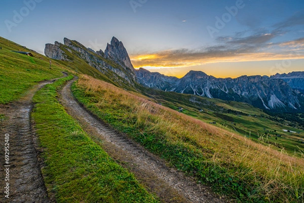 Obraz Golden sunrise at Seceda, Dolomites, Italy, A stunning spectacle bathes the rugged landscape and meadows in warm hues, creating a serene and radiant morning panorama.