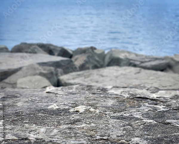 Fototapeta Empty stone base, empty flat stone on the background of the sea, rocky shore Background. Natural background. The backdrop. Space for text. Place for the product. Copy space