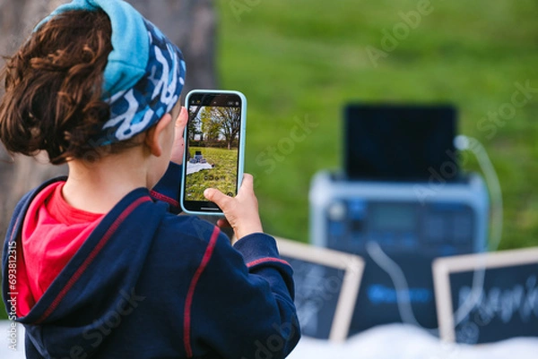 Fototapeta Kid taking a picture with the phone. 