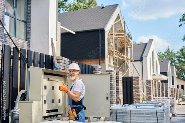 Obraz Electrical engineer approving power distribution box installation on site