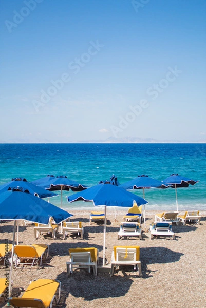 Obraz Vacation concept: empty beach with sunbeds and umbrellas, Blue sea in the background. Free copy space