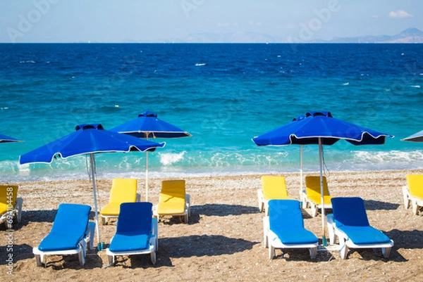 Obraz Summer and holiday concept: beach chairs and umbrellas, no people, empty beach, beautiful blue sea