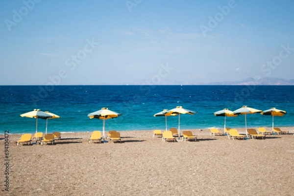 Obraz Summer and holiday concept: beach chairs and umbrellas, no people, empty beach, beautiful blue sea