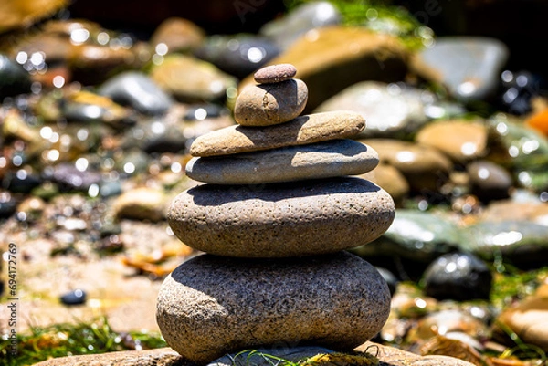 Fototapeta Tranquil Zen stacked rocks at the beach in harmony with nature.