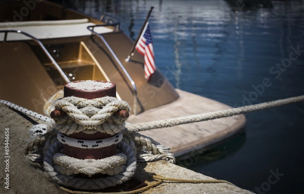 Obraz Mooring bollard with nautical rope knotted on it.