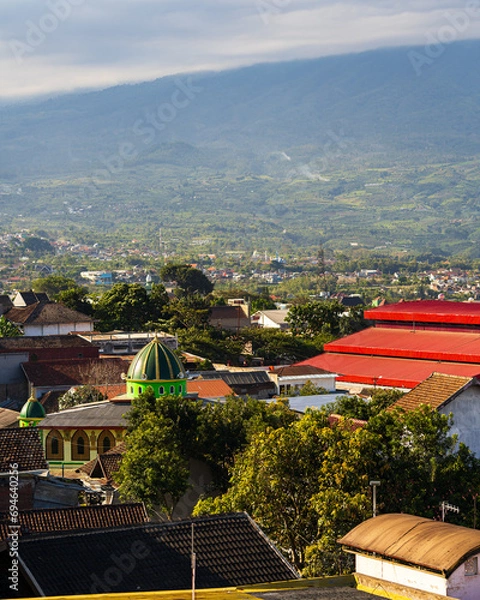 Fototapeta View of the city of Batu in East Java, Indonesia. In the background, there are mountains and a mosque with a green dome.