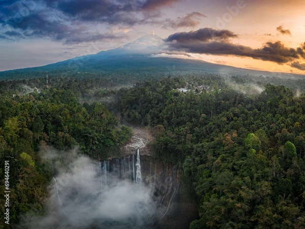 Fototapeta Aerial view of Tumpak Sewu Waterfall and Mount Semeru at sunrise located in East Java, Lumajang, Indonesia. Natural landscape background.